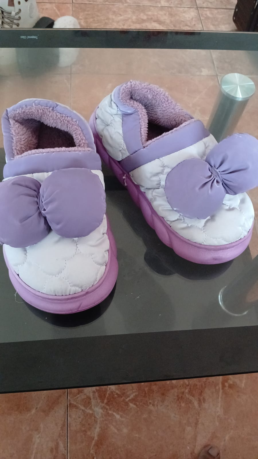 Quilted house slippers featuring large decorative bows